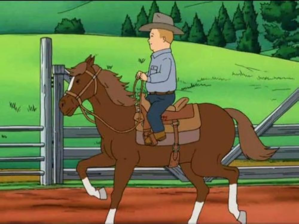 Bobby rides a horse in a cowboy hat, green grass and trees in background