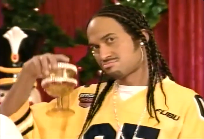 Keegan Michael Key as Ludacris at the Billboard awards, wearing long braids, yellow jersey, raising goblet