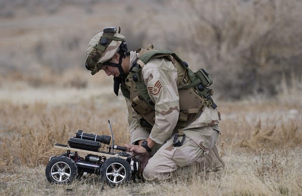 Air Force Staff Sgt. Lilly Smith attaches C-4 explosive to the front of a remote controlled vehicle